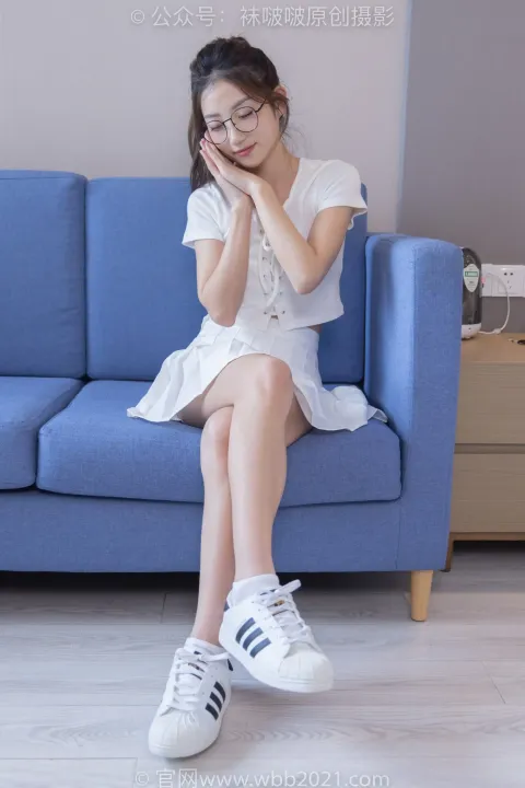阿拉夫德女人坐在蓝色沙发上，双手捂着脸