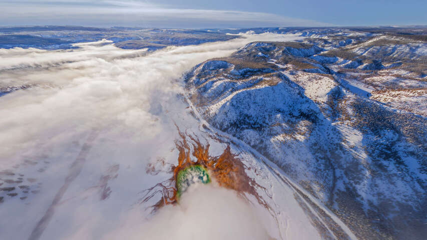 有一个单板滑雪者正在从雪山上下来
