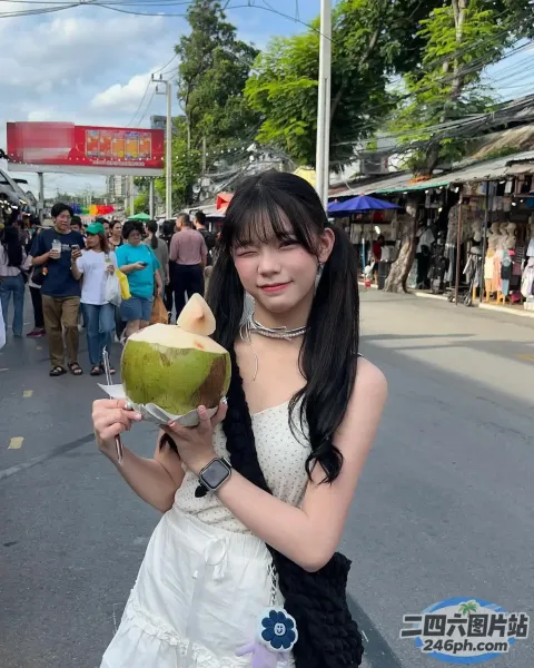 身穿白色连衣裙的阿拉伯女子在街上拿着椰子