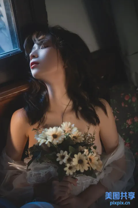 有一位女士坐在沙发上，手里拿着一束鲜花