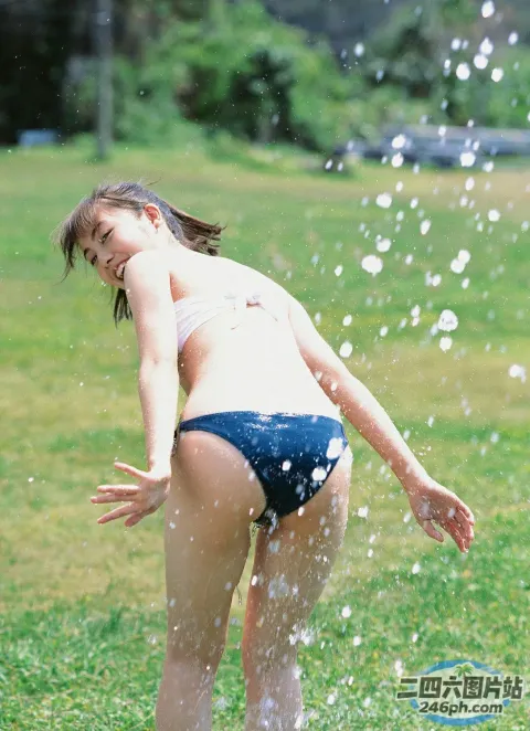 穿着比基尼玩洒水器的 araffe 女孩