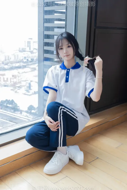 穿着白衬衫和蓝色裤子坐在窗台上的阿拉夫德女人