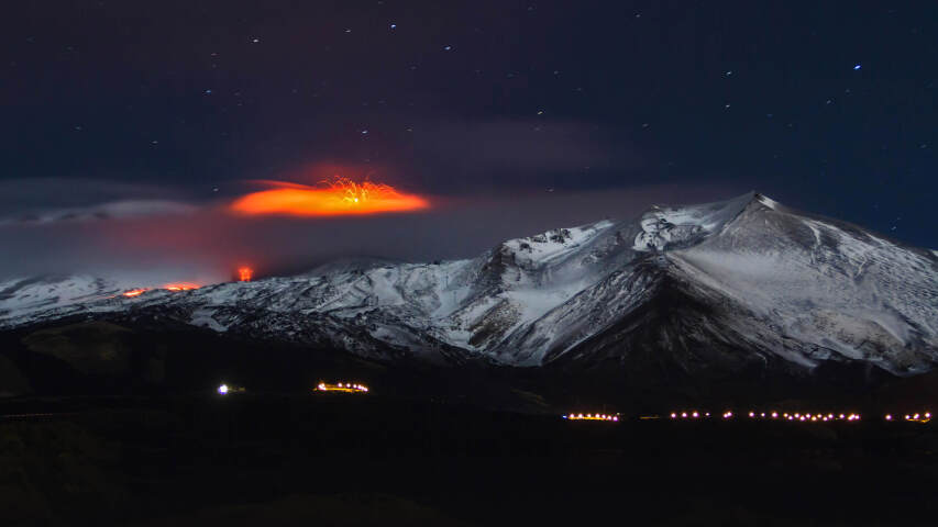 远处有火山的山脉，下面是一座城市
