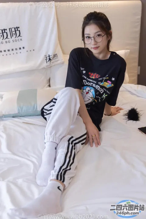 戴眼镜的 Araffe 女孩和一只猫坐在床上
