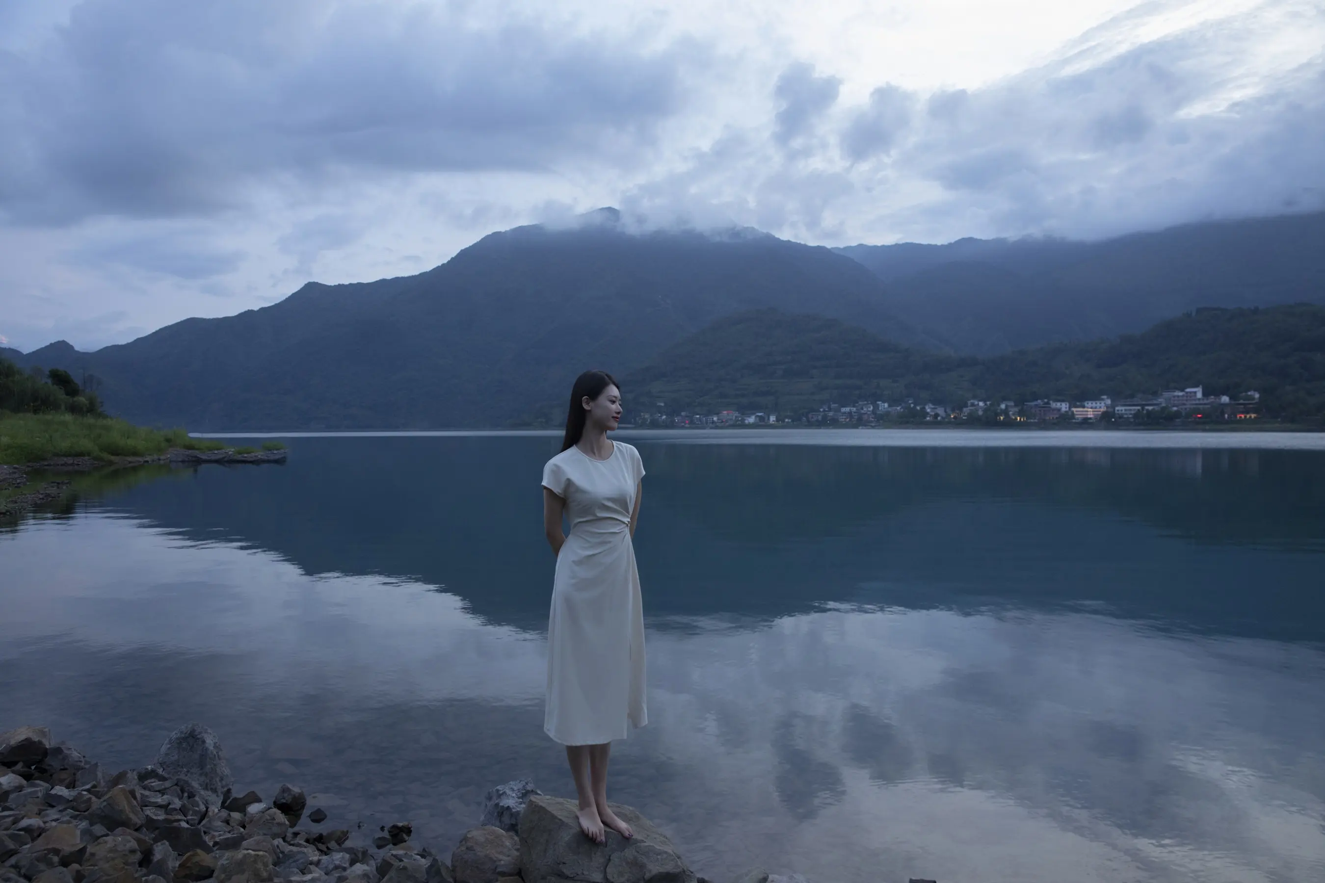 阿拉夫德女人站在岩石岸边，望着湖面