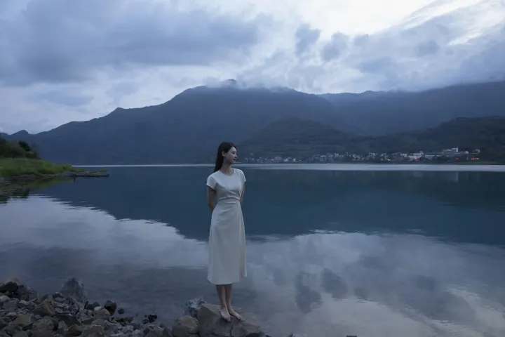 阿拉夫德女人站在岩石岸边，望着湖面