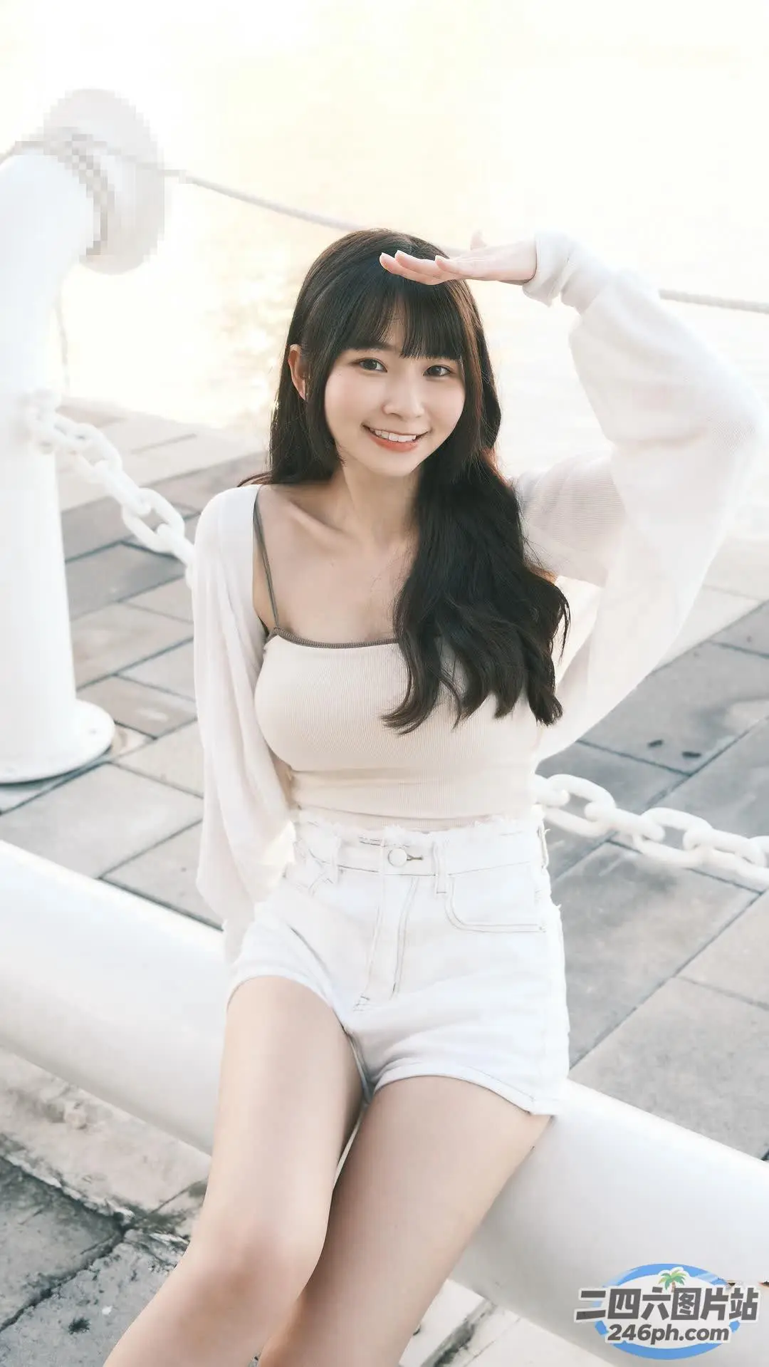 阿拉伯裔亚洲妇女坐在水边的白色栏杆上