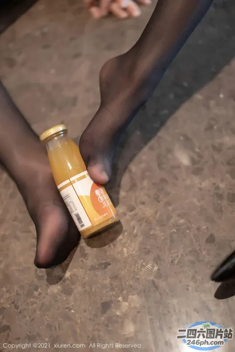 有人在地板上拿着一瓶果汁