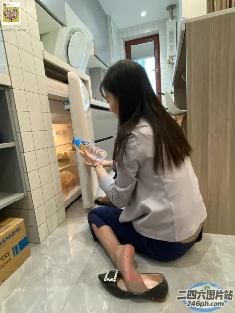 坐在冰箱前地板上的女人打开了门