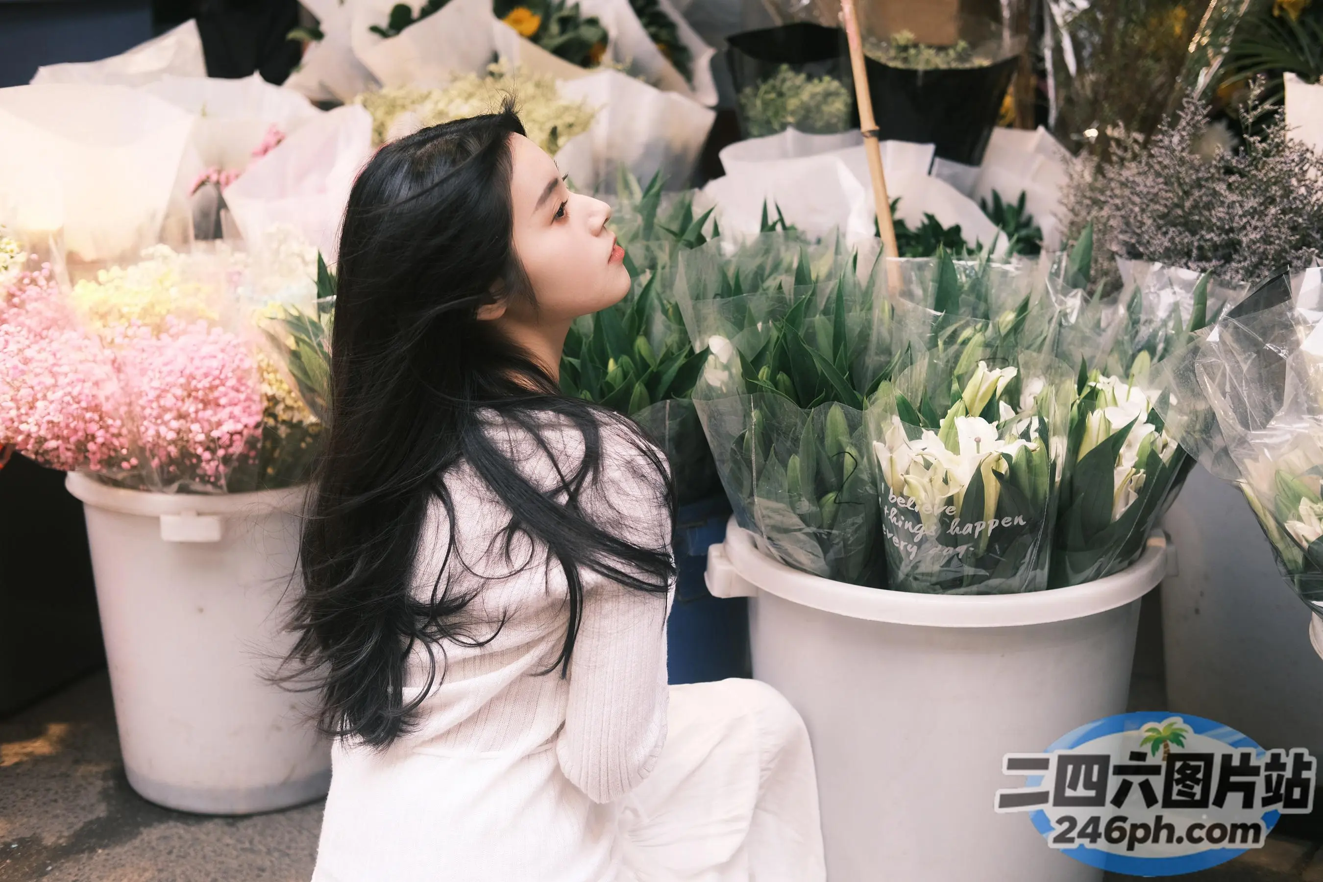 地上坐着一个女人，旁边是一束花