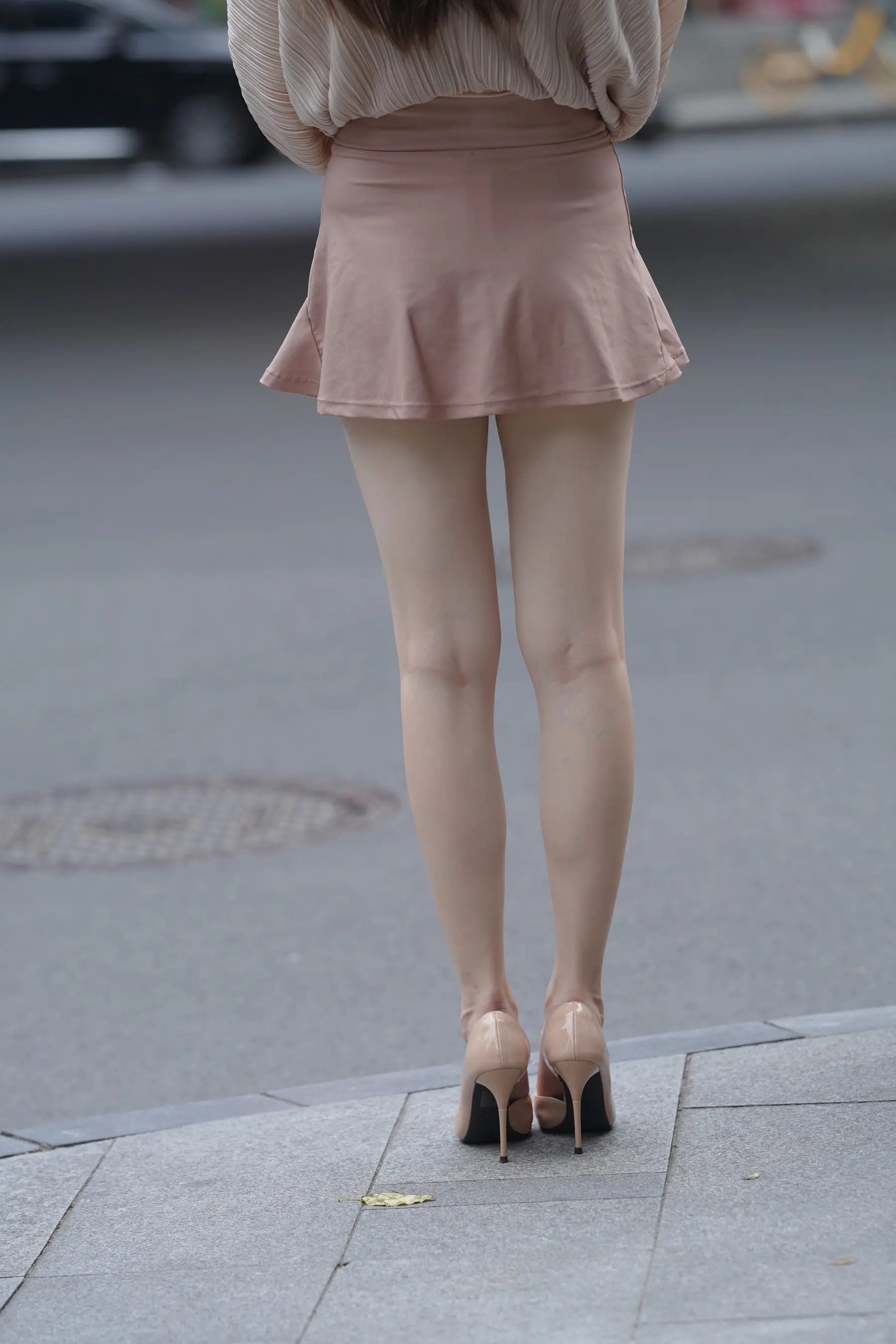穿着裙子和高跟鞋的 Araffed 女人走在街上