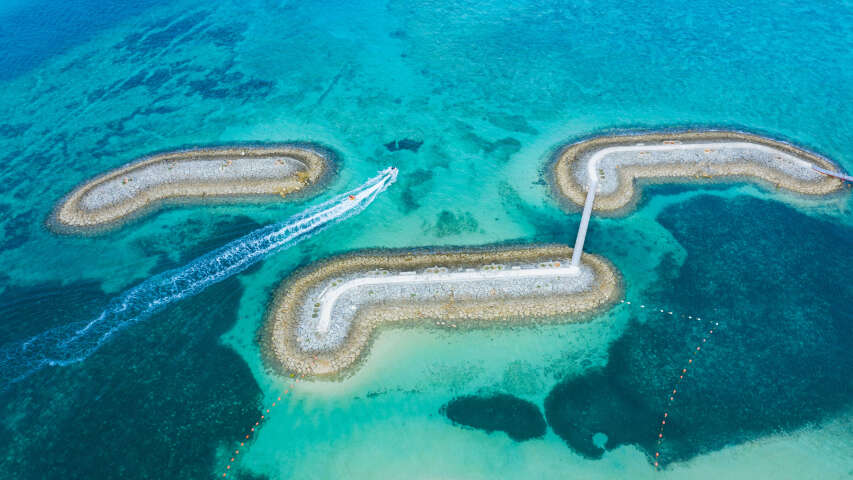 在海滩附近海洋中航行的船只的鸟瞰图