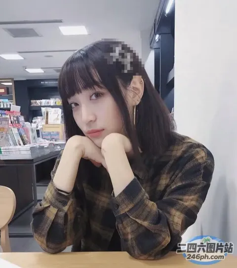 阿拉菲德女人坐在桌子旁，面前放着一台笔记本电脑