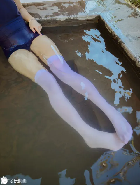 泳池里有个穿着蓝色裙子和紫色袜子的女人