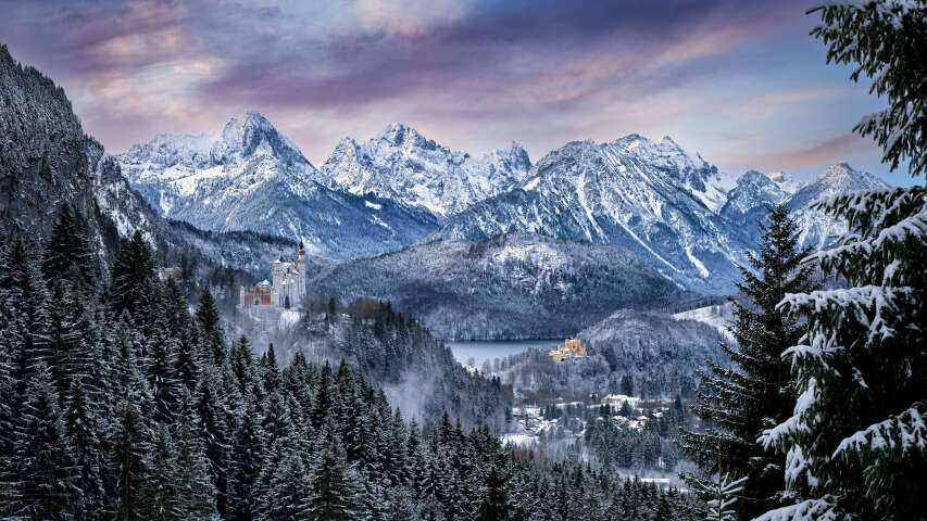 白雪皑皑的山脉和树木，前景是湖泊