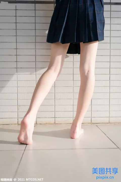 有一个穿着裙子的女人走在瓷砖地板上