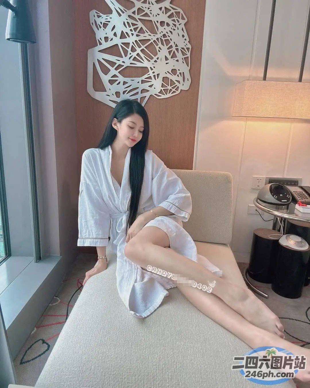 床上坐着一个穿着白色长袍的女人
