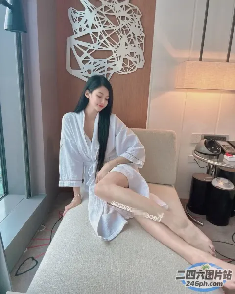 床上坐着一个穿着白色长袍的女人