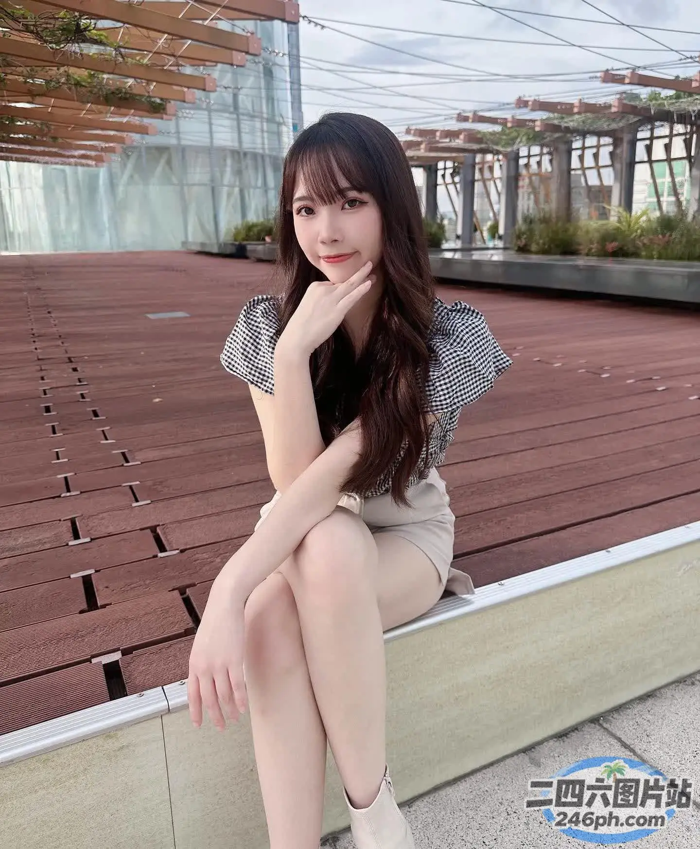 阿拉菲女人坐在长凳上，手放在下巴上