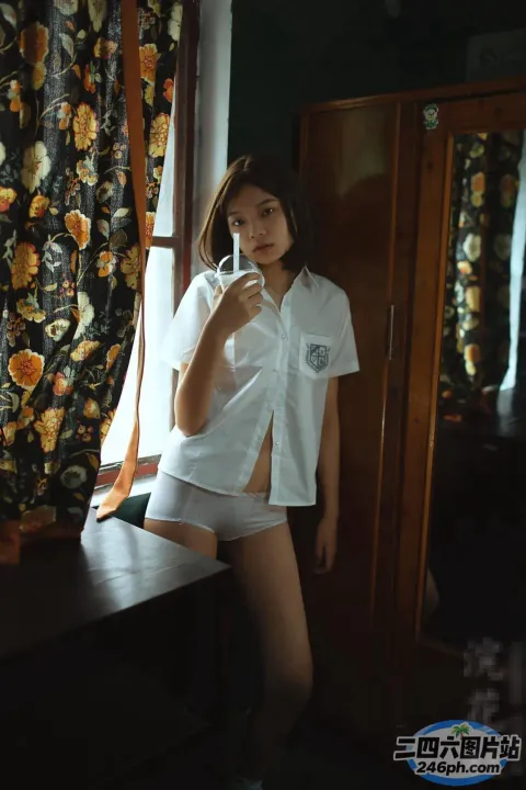 有个女人站在窗前，手里拿着手机