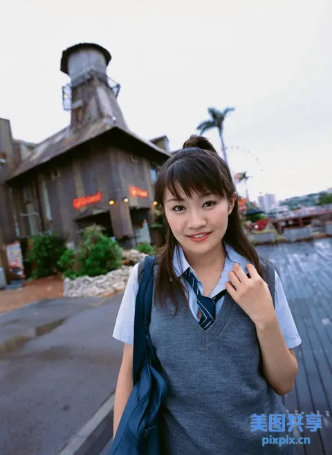 有个女人站在有钟楼的楼前
