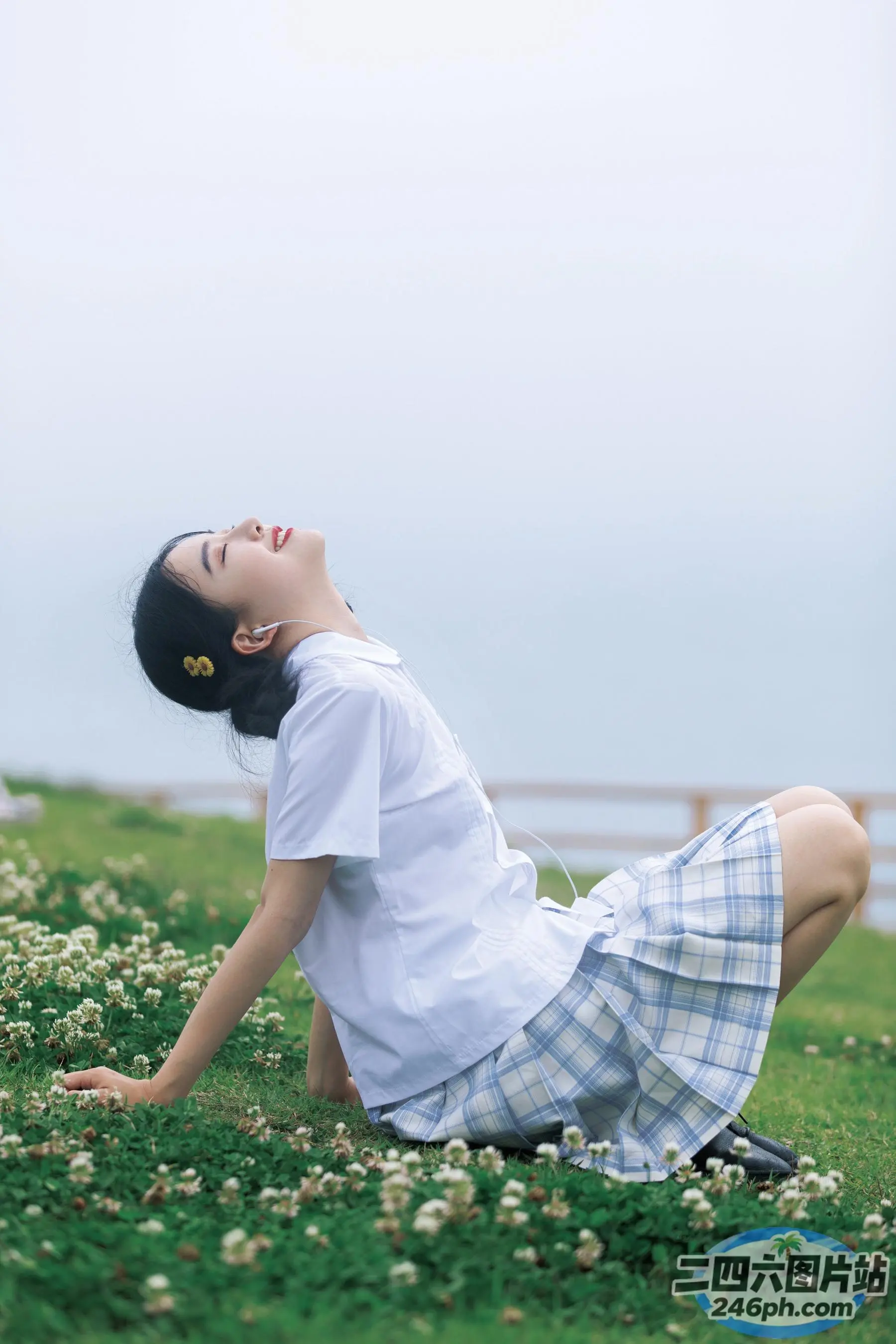 有一个女人闭着眼睛坐在草地上