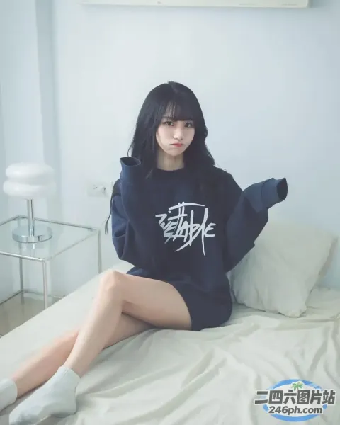 Araffe 坐在床上，床上铺着白色床单和黑色运动衫