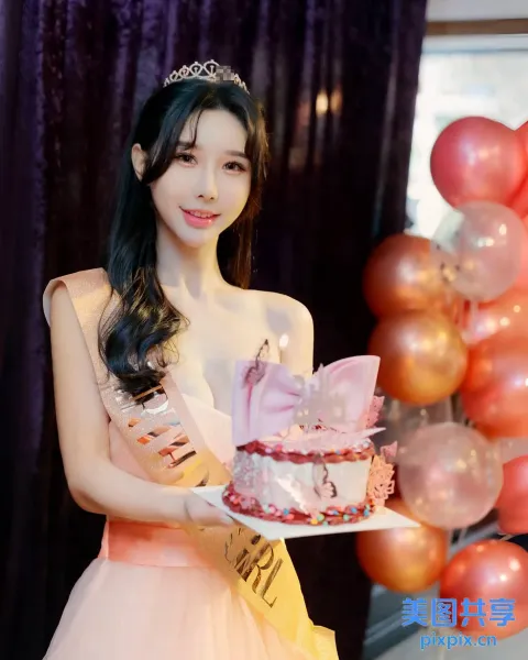 身穿粉红色连衣裙的阿拉伯女，手里拿着带蜡烛的蛋糕