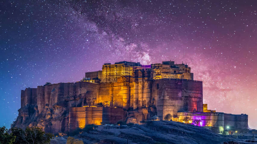 城堡上空星光灿烂的夜空，散发着粉红色的光芒
