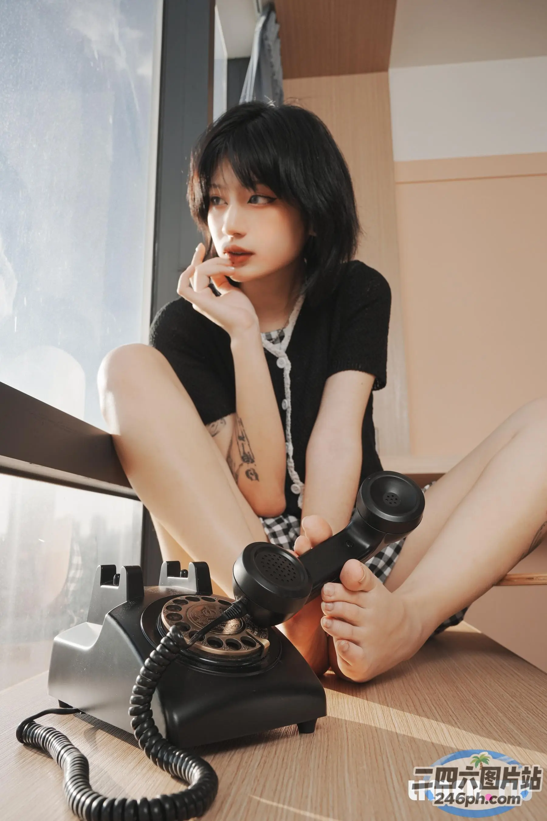 地板上坐着一个女人，手里拿着电话