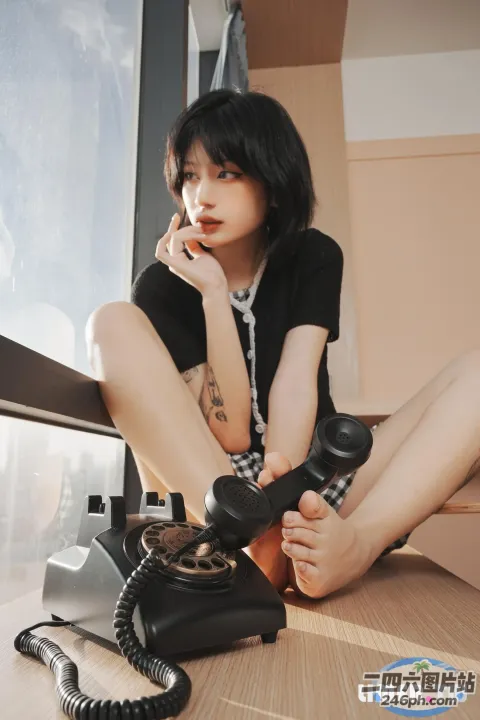 地板上坐着一个女人，手里拿着电话