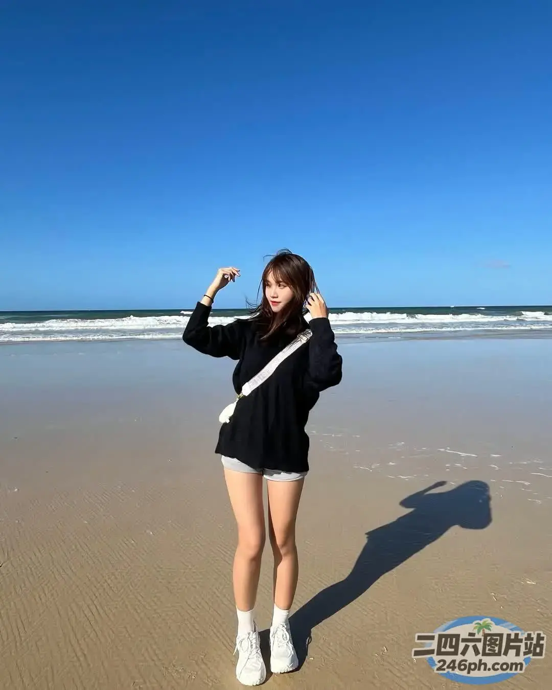 阿拉夫德女人站在海滩上，双臂高举