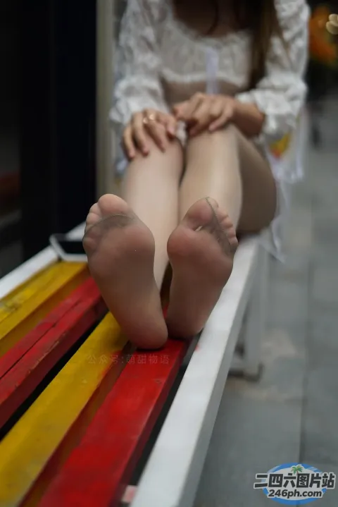 有个女人坐在长凳上，双脚放在长凳上