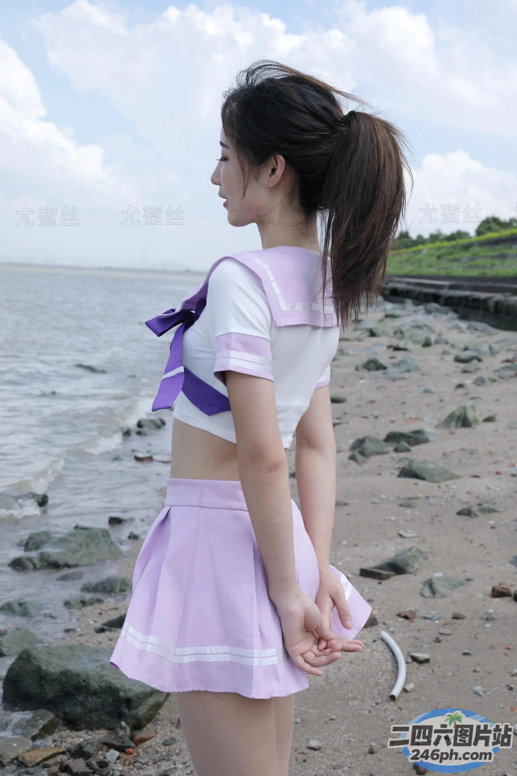 身穿紫色和白色制服的 arafed 亚洲女性站在海滩上