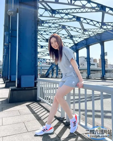 Arafed 亚洲女子拿着滑板在桥上摆姿势