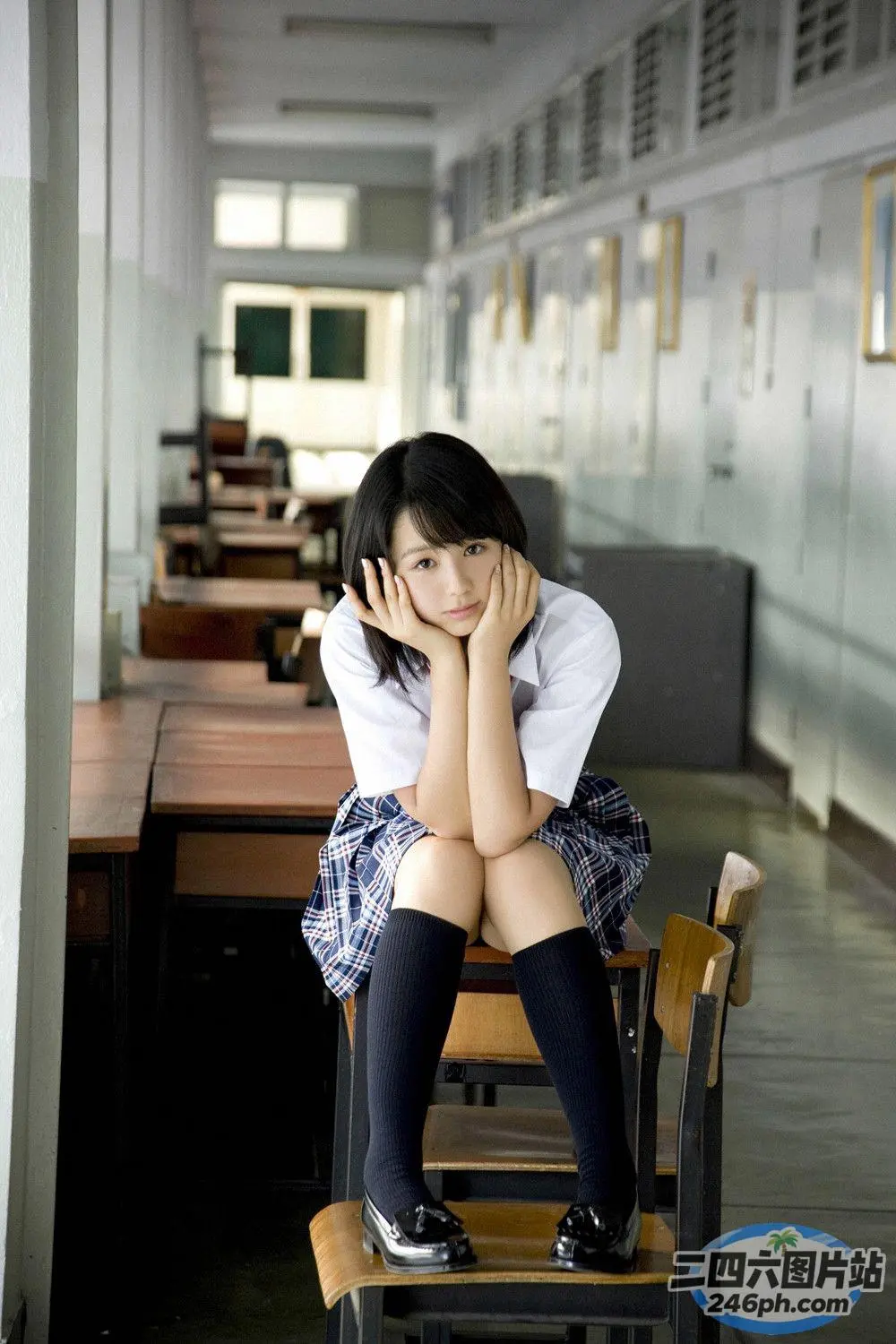 坐在学校走廊椅子上的 arafed 亚洲女孩