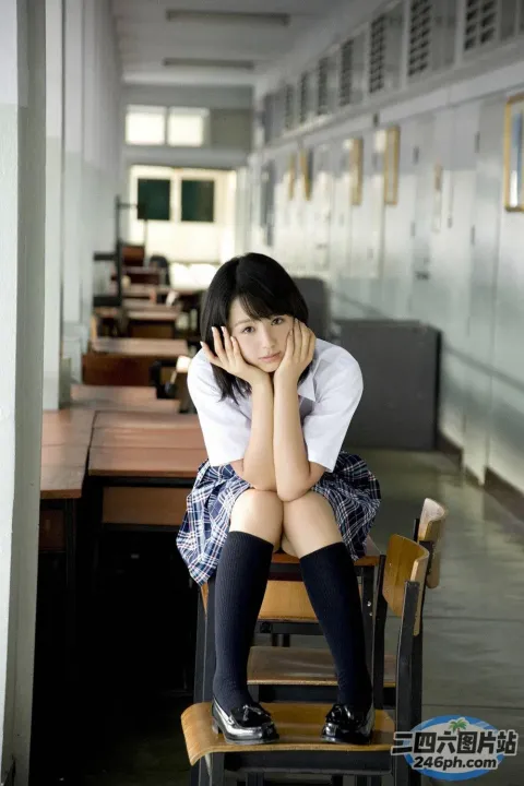 坐在学校走廊椅子上的 arafed 亚洲女孩