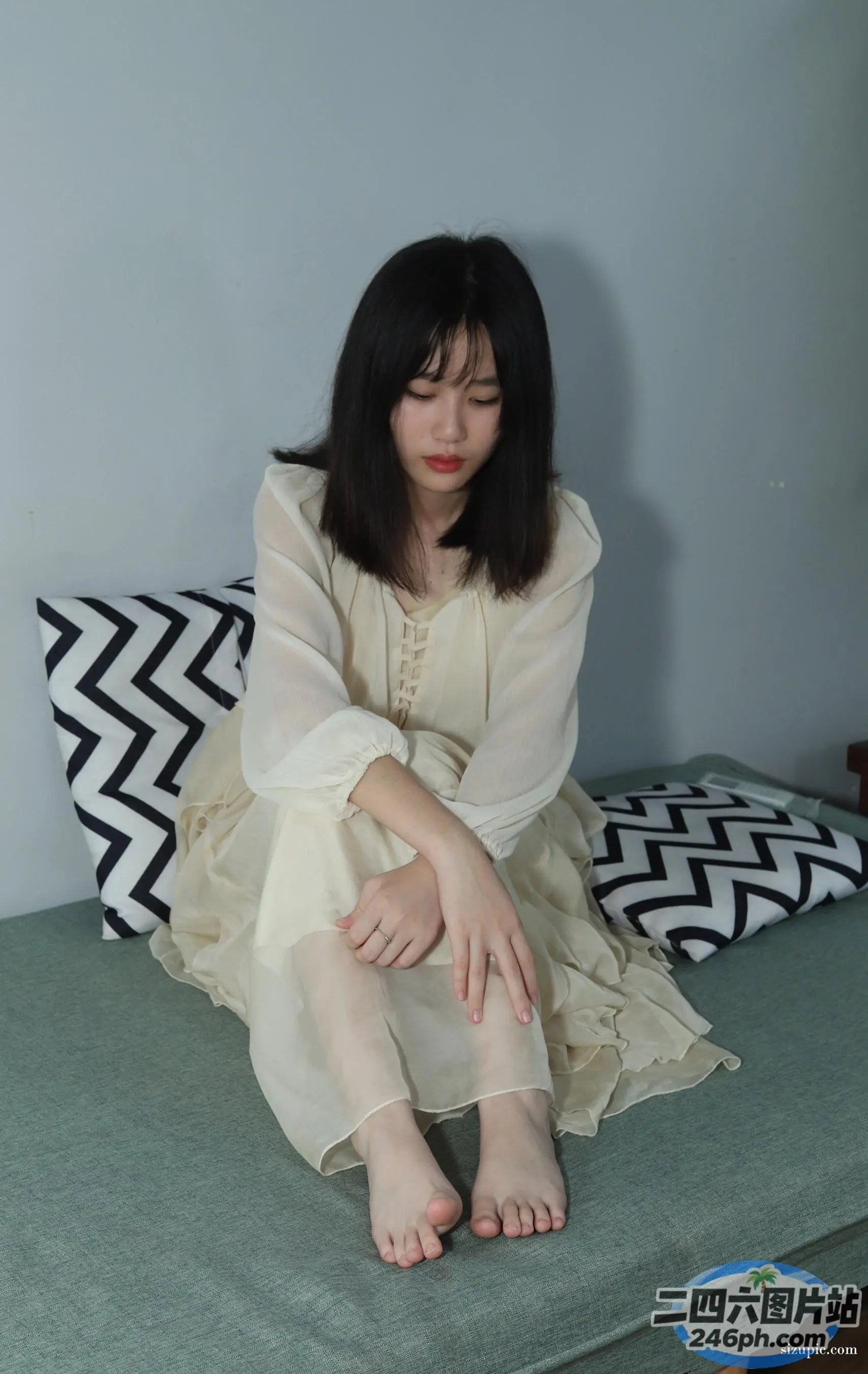 一个女人坐在床上拿着枕头的特写