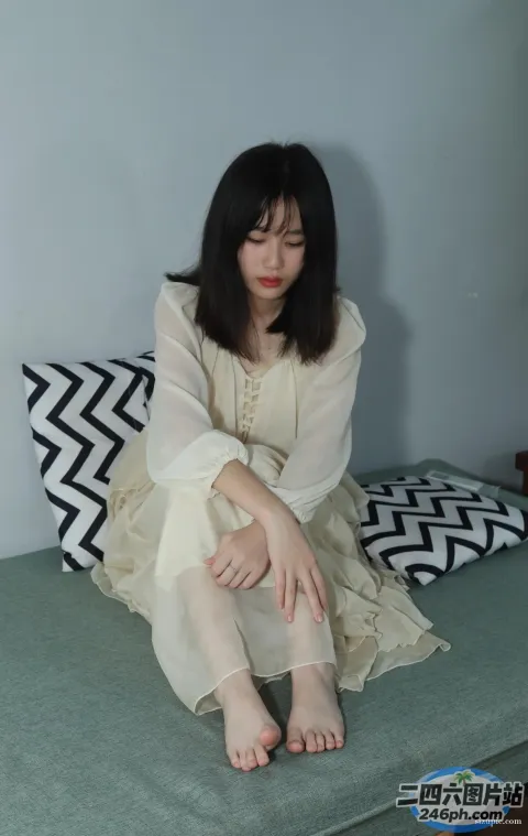一个女人坐在床上拿着枕头的特写