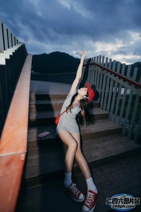 戴着红帽子和灰色衬衫的 arafed 女人站在楼梯上