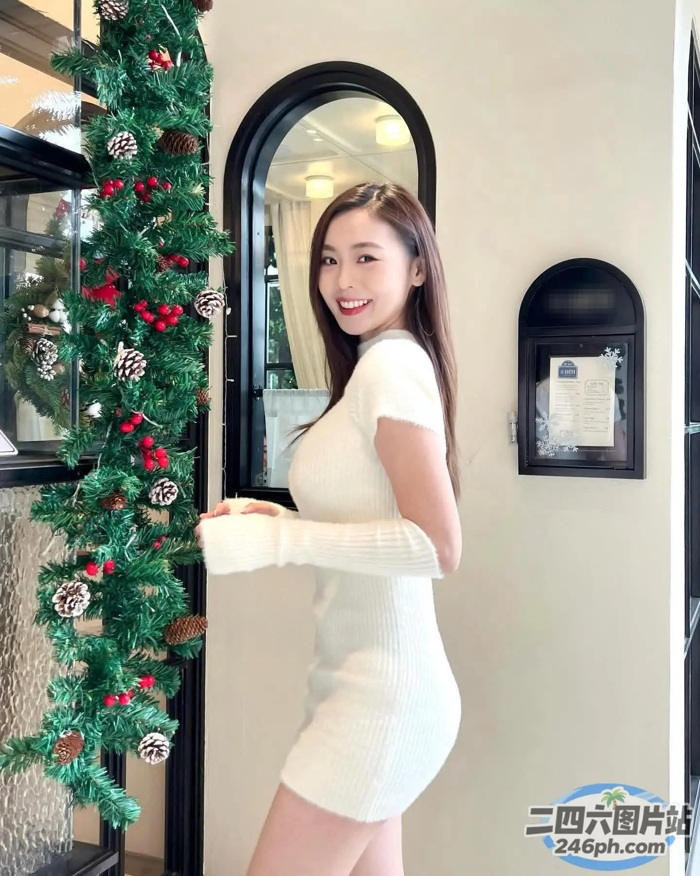 身穿白色连衣裙的 araffe 女子站在圣诞树前