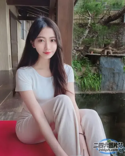 一个女人坐在池塘边的红色垫子上的特写