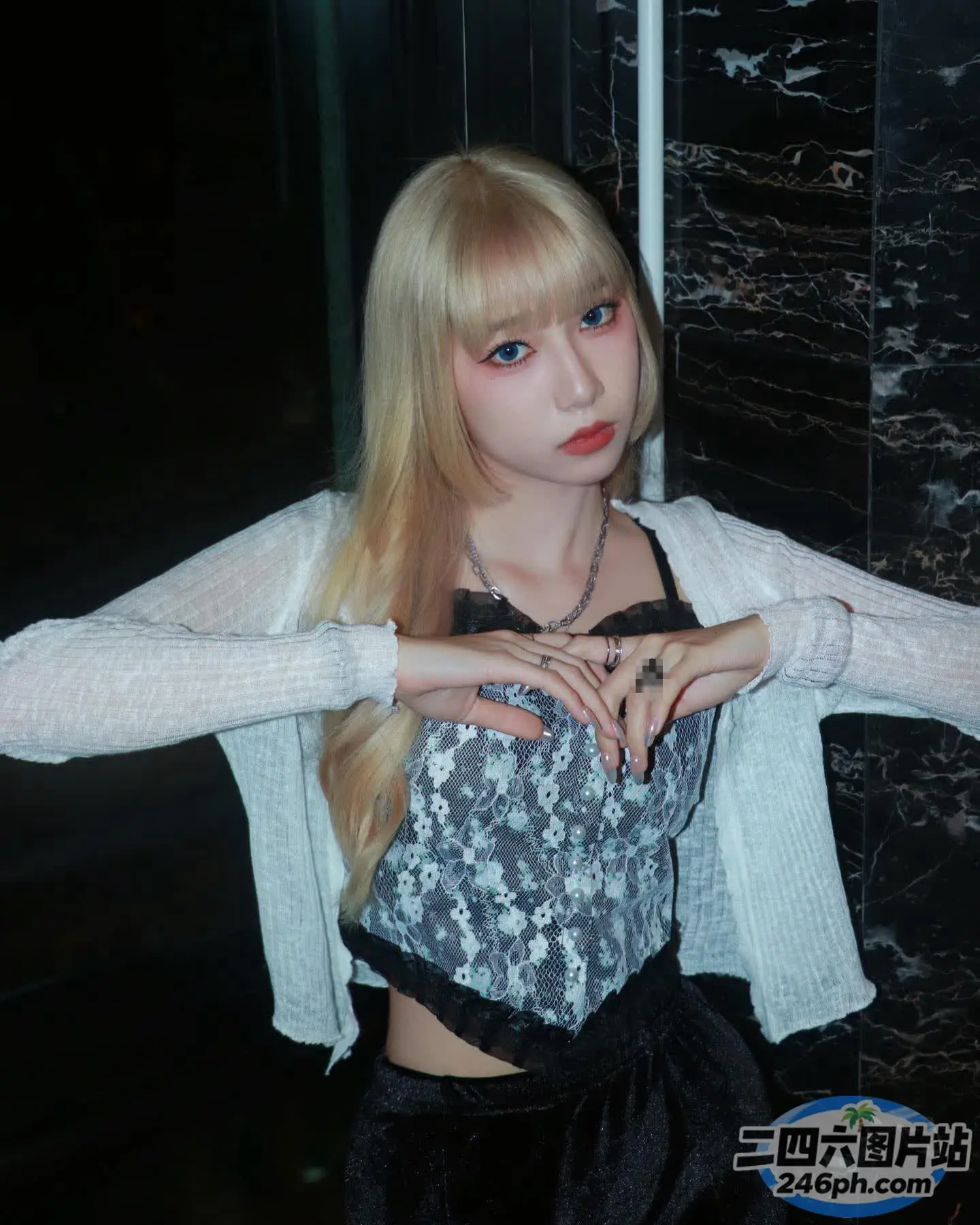 金发碧眼的女孩，身着黑白相间的衣服摆姿势