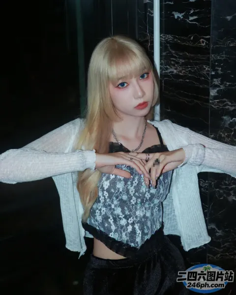金发碧眼的女孩，身着黑白相间的衣服摆姿势