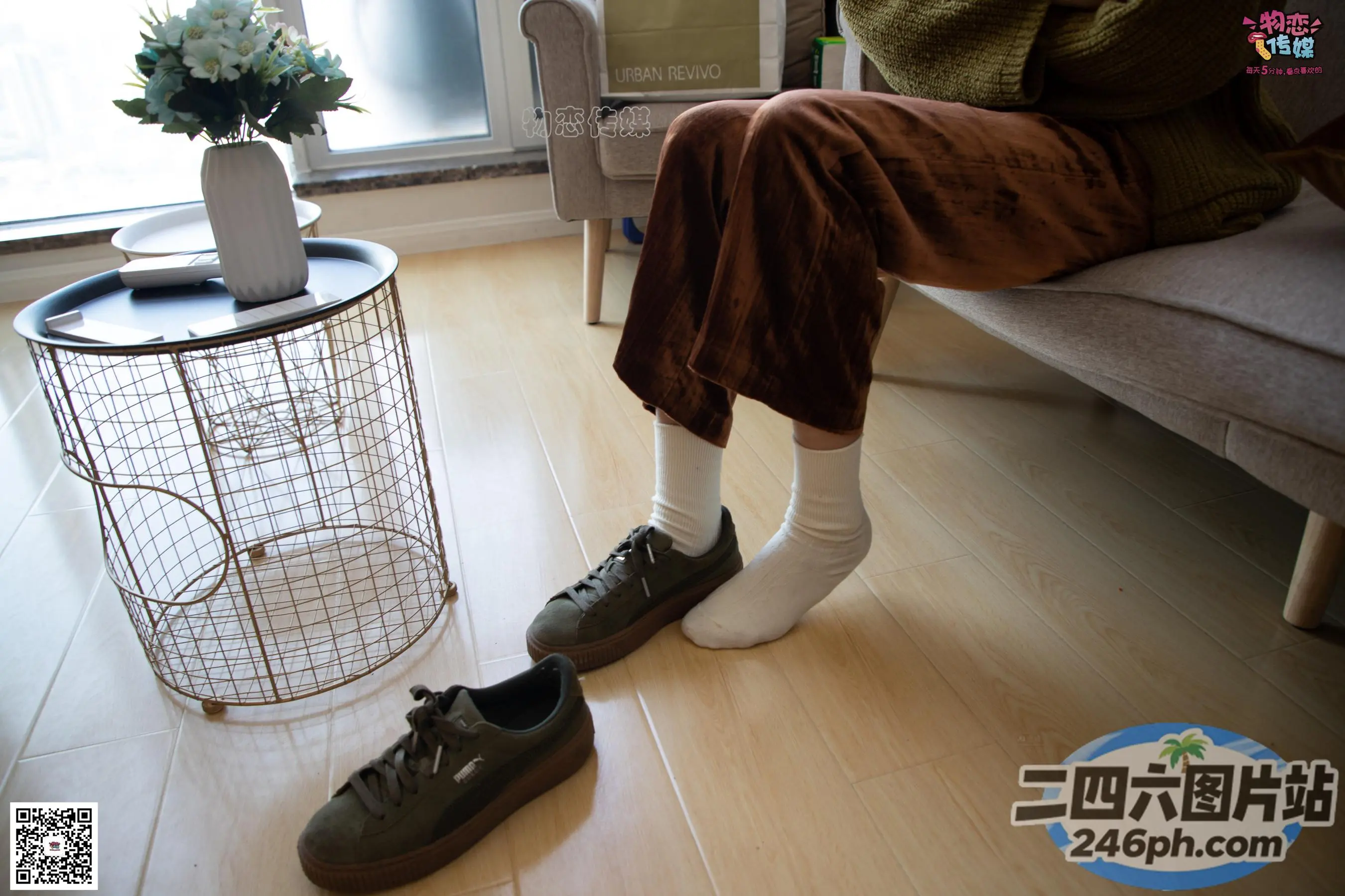 有人坐在沙发上，双脚抬起，穿着鞋子