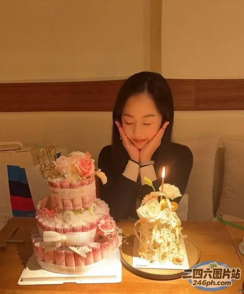 拿着蛋糕和蜡烛坐在桌子旁的女人