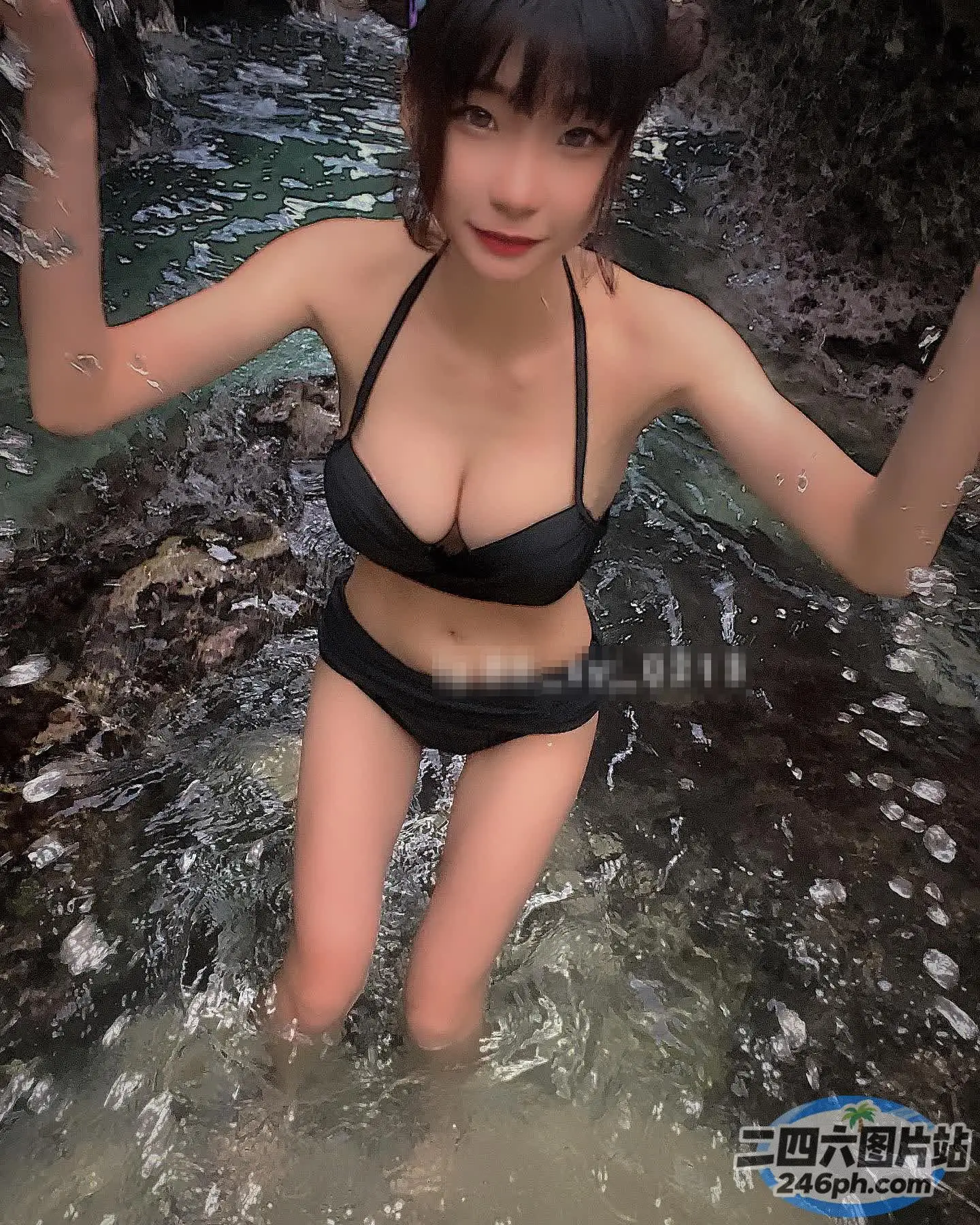 身穿黑色比基尼的 arafed 亚洲女子在河中摆姿势