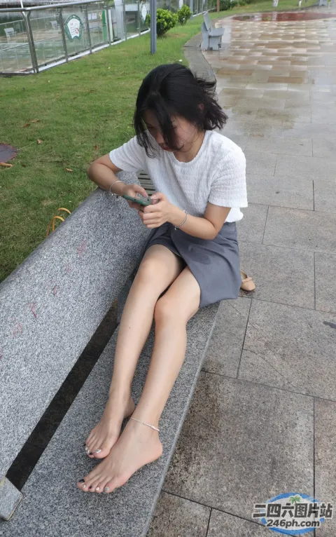坐在长凳上用手机的 Araffed 女人