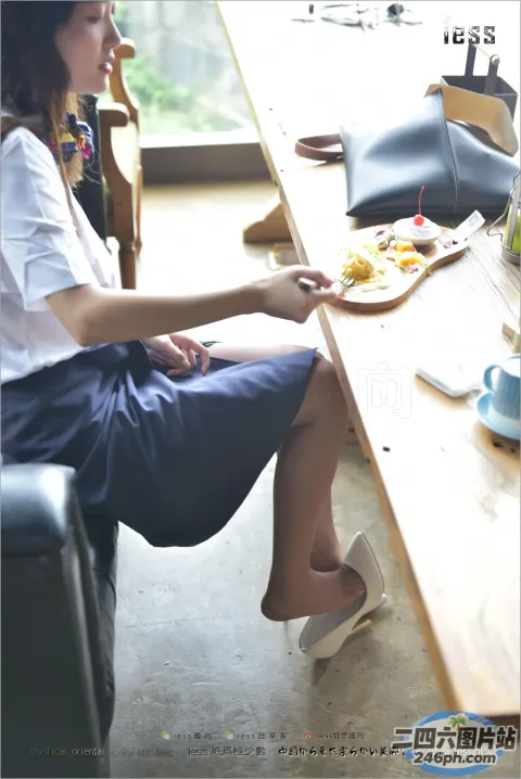 有个女人坐在一张桌子旁，桌上放着一盘食物