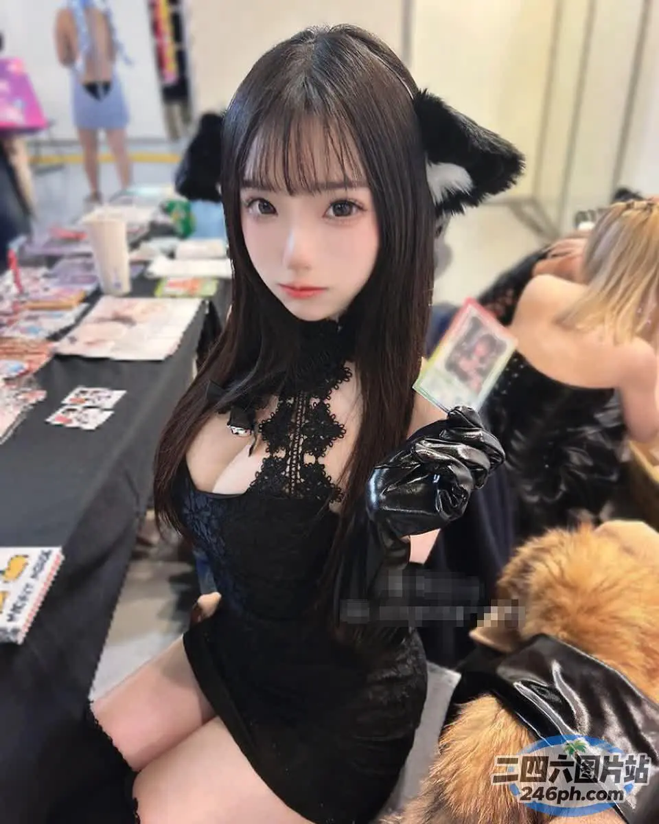 一个穿着黑色连衣裙的女人坐在桌子上的特写